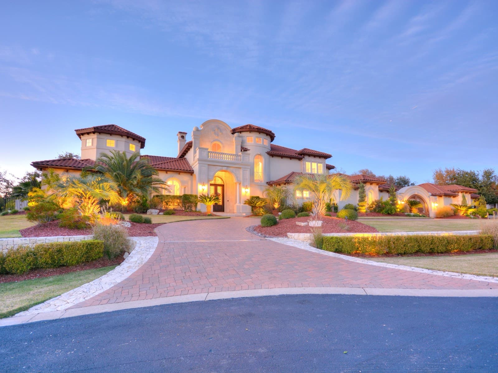 Twilight front elevation of the lakefront estate at 210 Bella Cima Drive, Austin
