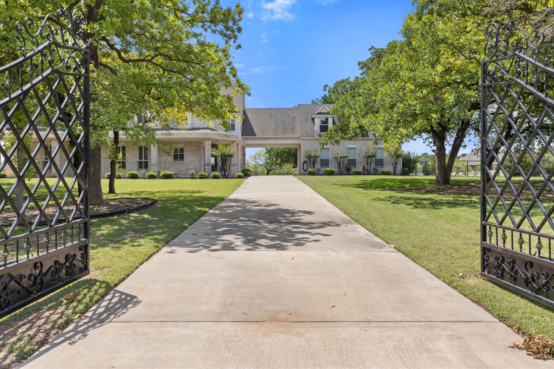 Open wrought-iron gates framing the drive at 259 King Ranch Court